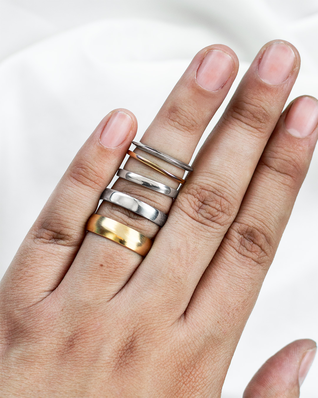 Diferentes anillos mostrando cómo la talla puede variar según el dedo y el diseño.