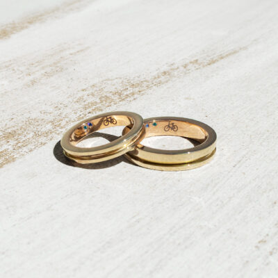 Argollas de matrimonio personalizadas con bicicleta y birthstones en oro amarillo 14K