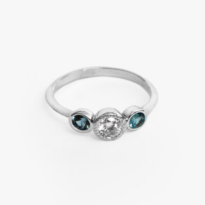 Anillo trilogía con moissanita y topacios azules en oro blanco 14K