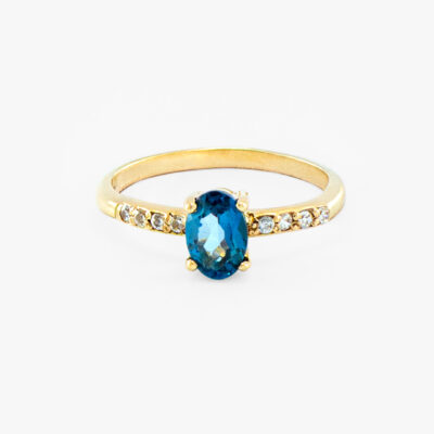 Anillo solitario con topacio azul oval y diamantes en oro amarillo 14K