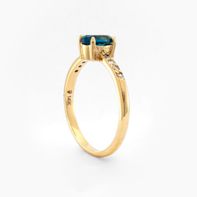 Anillo solitario con topacio azul oval y diamantes en oro amarillo 14K